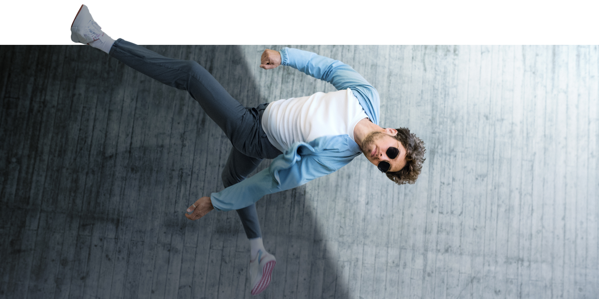  Man jumping in the air wearing glasses with ZEISS PhotoFusion X in tinted state 